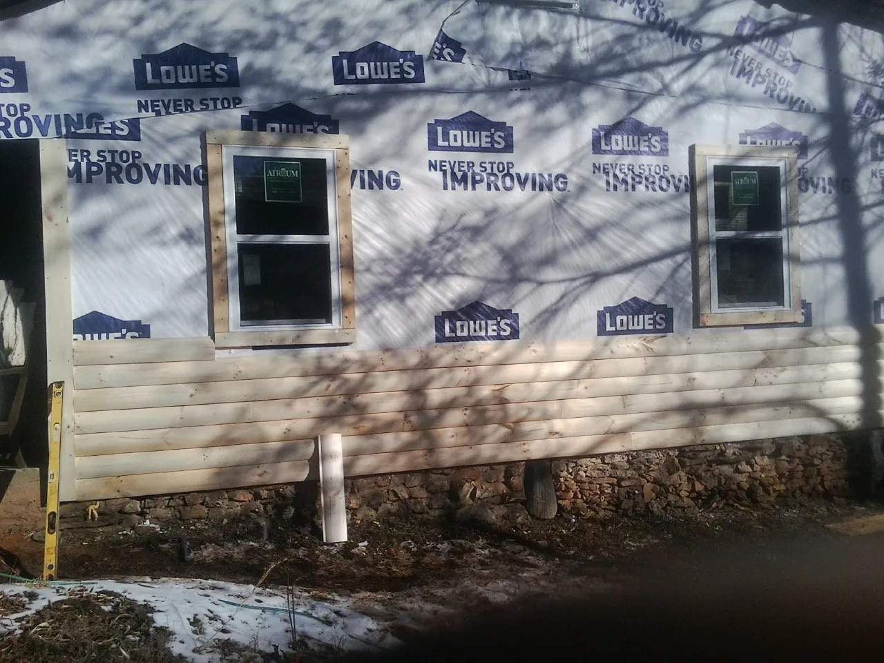 House wrap and new log siding going up on an exterior wall in Wadmalaw Island